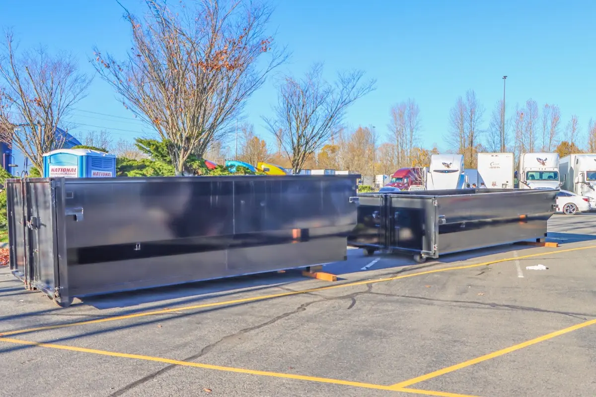 Professional dumpster rental service with roll-off container on residential driveway in Farmingdale